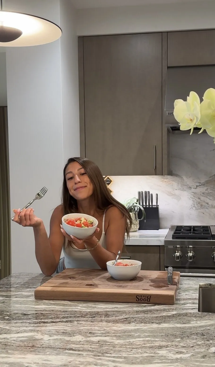 Tia holding a bowl of food in her kitchen